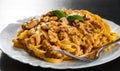 Sliced fried chicken breast meat in a creamy sauce with bavette pasta in a plate