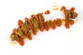 Sliced fried pork sausage with curry ketchup and curry powder where some pieces are missing Royalty Free Stock Photo