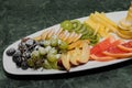 Sliced fruit on a white plate, grapes, kiwi, orange, pear Royalty Free Stock Photo