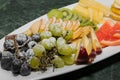 Sliced fruit on a white plate, grapes, kiwi, orange, pear Royalty Free Stock Photo