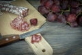 Sliced Fuet and grapes on wooden cutting board Royalty Free Stock Photo