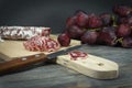 Sliced Fuet and grapes on wooden cutting board Royalty Free Stock Photo