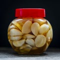 Sliced garlic cloves in honey in glass jar, closeup. Honey infused garlic