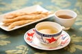 sliced ginseng root on saucer beside ginseng tea in mug Royalty Free Stock Photo