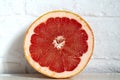 Sliced grapefruit on a background of a white brick wall Royalty Free Stock Photo