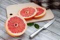 Sliced grapefruit on a cutting board on a light wooden background Royalty Free Stock Photo