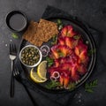 Sliced Gravlax,  scandinavian beet cured salmon  served with red onion, capers,  lemon and crisp bread Royalty Free Stock Photo