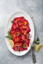 Sliced Gravlax,  scandinavian beet cured salmon  served with red onion, capers and lemon on white plate Royalty Free Stock Photo
