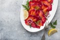 Sliced Gravlax,  scandinavian beet cured salmon  served with red onion, capers and lemon on white plate Royalty Free Stock Photo