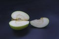 sliced green granny apple with a piece on a black background top view Royalty Free Stock Photo