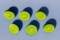 Sliced green and juicy limes and lemons on a blue background with hard shadows Royalty Free Stock Photo