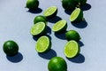 Sliced green and juicy limes and lemons on a blue background with hard shadows Royalty Free Stock Photo