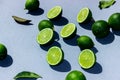 Sliced green and juicy limes and lemons on a blue background with hard shadows Royalty Free Stock Photo