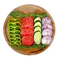 Sliced green sweet pepper, tomato, cucumber and red onion on a round wooden board Royalty Free Stock Photo