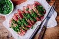 Sliced grilled barbecue beef steak with green chimichurri sauce Royalty Free Stock Photo