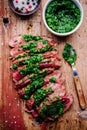 Sliced grilled barbecue beef steak with green chimichurri sauce Royalty Free Stock Photo