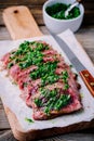 Sliced grilled barbecue beef steak with green chimichurri sauce Royalty Free Stock Photo