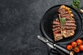 Sliced Grilled Florentine steak. T bone meat beef. Black background. Top view. Copy space