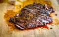 Sliced grilled juicy marinated beef flank steak on wooden board