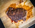 Sliced grilled juicy marinated beef flank steak on wooden board