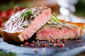 Sliced grilled meat barbecue steak Striploin with knife and fork carving set on black stone slate. Royalty Free Stock Photo