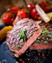 Sliced grilled meat barbecue steak Striploin with knife and fork carving set on black stone slate. Royalty Free Stock Photo