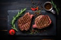 Sliced grilled meat steak with spices rosemary and pepper on black marble board