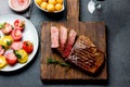 Sliced grilled medium rare beef steak served on wooden board Barbecue, bbq meat beef tenderloin. Top view, slate background Royalty Free Stock Photo