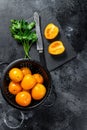 Sliced in half raw yellow cherry tomato. Black background. Top view Royalty Free Stock Photo