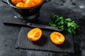 Sliced in half raw yellow cherry tomato. Black background. Top view Royalty Free Stock Photo