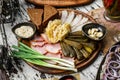 Sliced ham, bacon, lard, pickles, green onions, slices of rye bread on cutting board over rustic background. Appetizer for vodka, Royalty Free Stock Photo