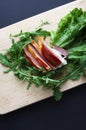 Sliced ham with fresh green lettuce leaves on a cutting board. Royalty Free Stock Photo