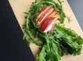 Sliced ham with fresh green lettuce leaves on a cutting board. Royalty Free Stock Photo