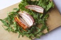 Sliced ham with fresh green lettuce leaves on a cutting board. Royalty Free Stock Photo