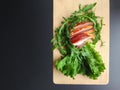 Sliced ham with fresh green lettuce leaves on a cutting board. Royalty Free Stock Photo