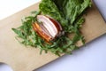 Sliced ham with fresh green lettuce leaves on a cutting board. Royalty Free Stock Photo