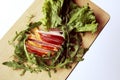 Sliced ham with fresh green lettuce leaves on a cutting board. Royalty Free Stock Photo