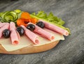 Sliced ham salami decorated on wooden board with olives, tomato Royalty Free Stock Photo