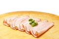 Sliced ham on wooden plate