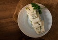 Sliced herby cheese served in a white plate