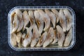 Sliced herring in oil sauce closeup, top view