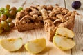 Sliced homemade american apple pie on brown wooden table with raisins and fresh fruits - apples, plums and grapes Royalty Free Stock Photo