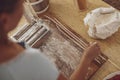 Sliced homemade noodles on a noodle slicer over a kitchen wooden board and a bag of flour Royalty Free Stock Photo