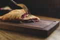 Sliced homemade strudel with cherry close-up on a dark wooden cutting board horizontal. Royalty Free Stock Photo