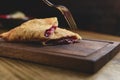 Sliced homemade strudel with cherry close-up on a dark wooden cutting board horizontal. Royalty Free Stock Photo