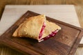 Sliced homemade strudel with cherry close-up on a dark wooden cutting board horizontal. Royalty Free Stock Photo