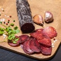 Sliced horse sausage, herbs and spices on cutting board. Selective focus. Shallow depth of field Royalty Free Stock Photo