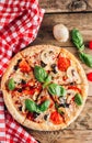 Sliced italian pizza with salami, mozzarella, mushroom, tomatoes, black olives and basil leaves on black background. Italian Royalty Free Stock Photo