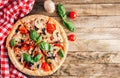 Sliced italian pizza with salami, mozzarella, mushroom, tomatoes, black olives and basil leaves on black background. Italian Royalty Free Stock Photo