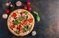 Sliced italian pizza with salami, mozzarella, mushroom, tomatoes, black olives and basil leaves on black background. Italian Royalty Free Stock Photo